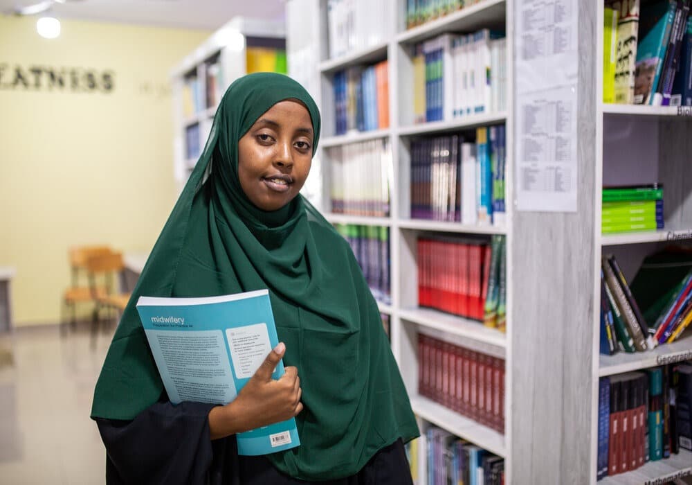 Teacher with medical text in library