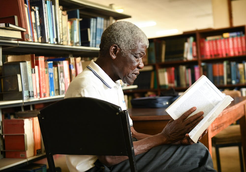 An older man reading in the library