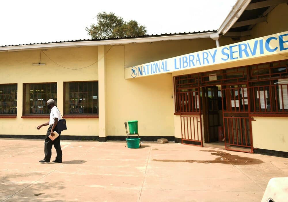 An older man leaving the library with books to read 