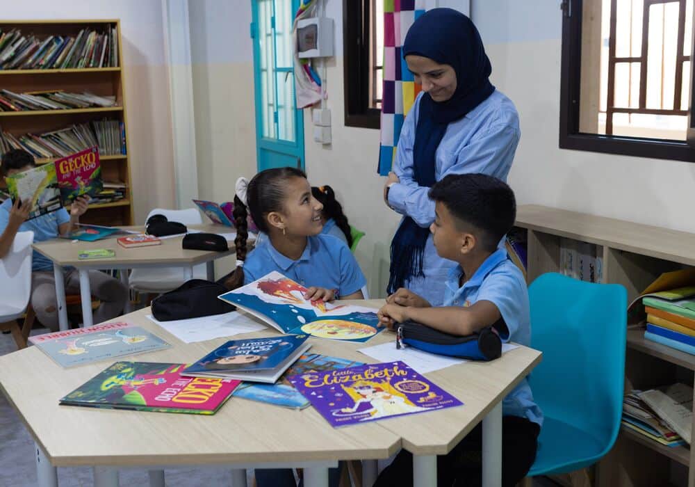 Nessrine and students looking at books