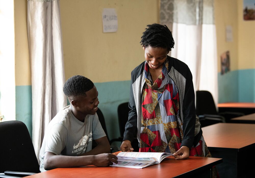 Peace reading with a student at Dzaleka Refugee Camp library