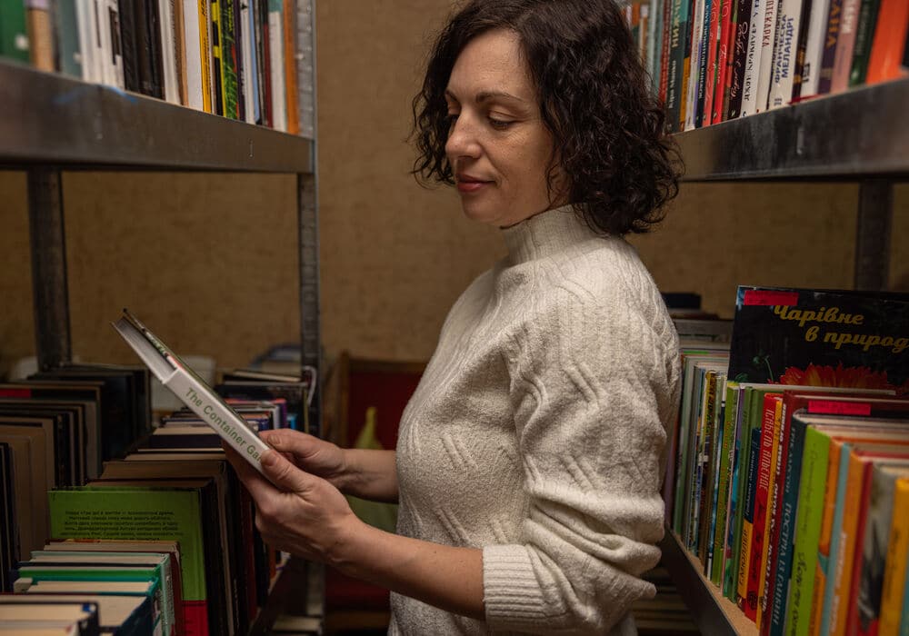 Iryna looking at books in the library