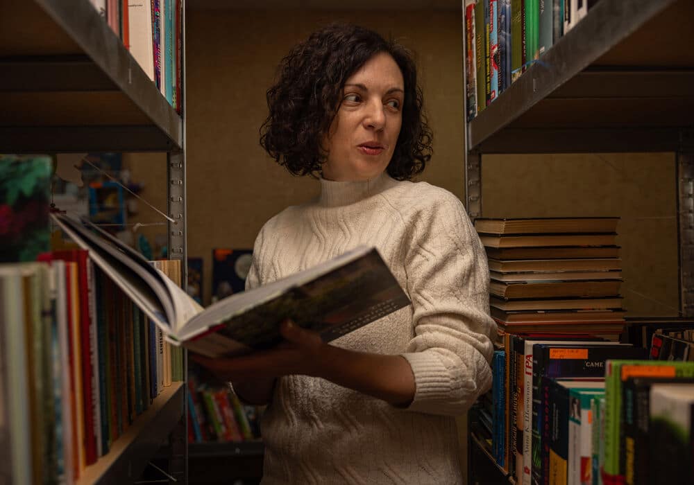 Iryna looking at books in the library