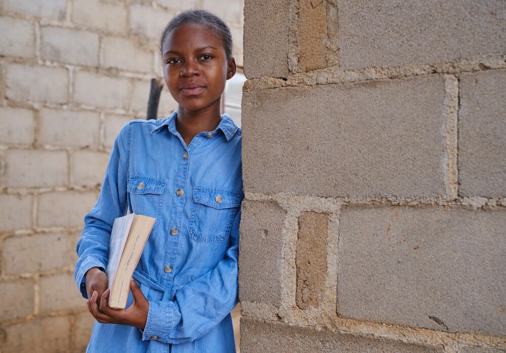 Tariro carrying a book home