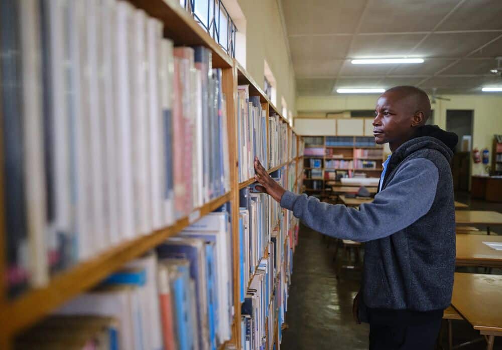 Timothy looking at books in the library